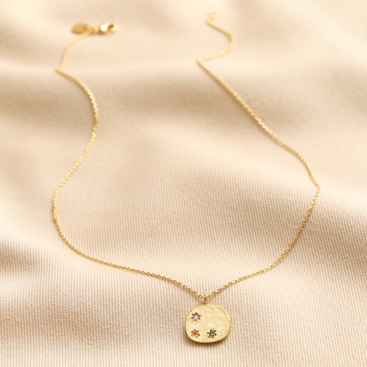 Multicoloured Crystal Daisy Disc Pendant Necklace in Gold full length on neutral coloured fabric