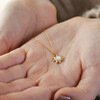 Model Holding Opal Sun Pendant Necklace in Gold in Palm of Hand