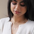 Model Wearing Opal Sun Pendant Necklace in Silver Layered With Other Silver Necklaces