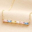Pastel Baguette Crystal Bar Pendant Necklace in Gold close up on beige coloured fabric