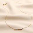 Pastel Baguette Crystal Bar Pendant Necklace in Gold full length on neutral coloured fabric