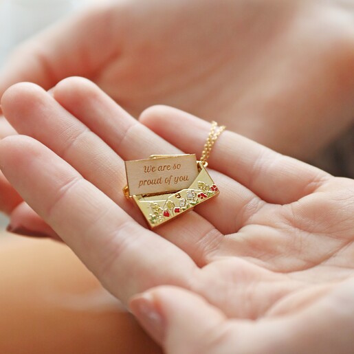 Model holding Personalised Wildflower Envelope Locket Pendant Necklace in Gold in palm of hand with token outside of locket