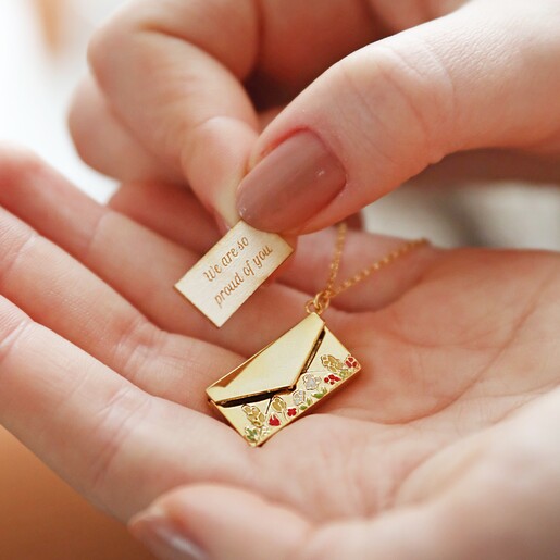 Model holding Personalised Wildflower Envelope Locket Pendant Necklace in Gold in palm of hand picking token up