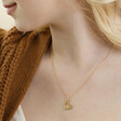 Model Wearing Larger Heart Pendant From Set of 2 Friendship Heart Pendant Necklaces in Gold