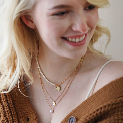 Model Wearing Layered With Other Gold Necklaces Model Wearing Talisman Charm Pearl and Chain Necklace in Gold Layered With Other Gold Necklaces