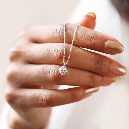 Model Holding Tiny Molten Heart Pendant Necklace in Silver