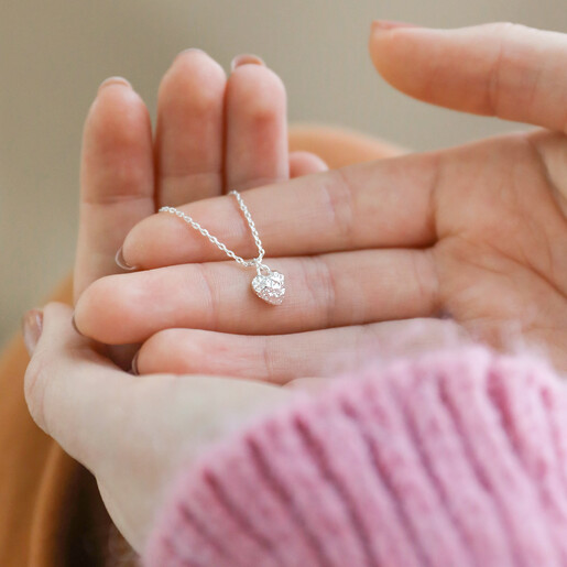 Model Holding Tiny Molten Heart Pendant Necklace in Silver 