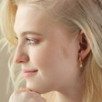 Model Wearing Opal Sun Huggie Hoop Earrings in Gold