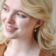 Model Smiling Wearing Opal Sun Huggie Hoop Earrings in Silver