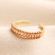 Adjustable Champagne Baguette Crystal Band Ring in Gold laid on top of beige coloured fabric