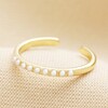 Adjustable Pearl Band Ring in Gold on Beige Fabric