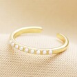 Adjustable Pearl Band Ring in Gold on Beige Fabric