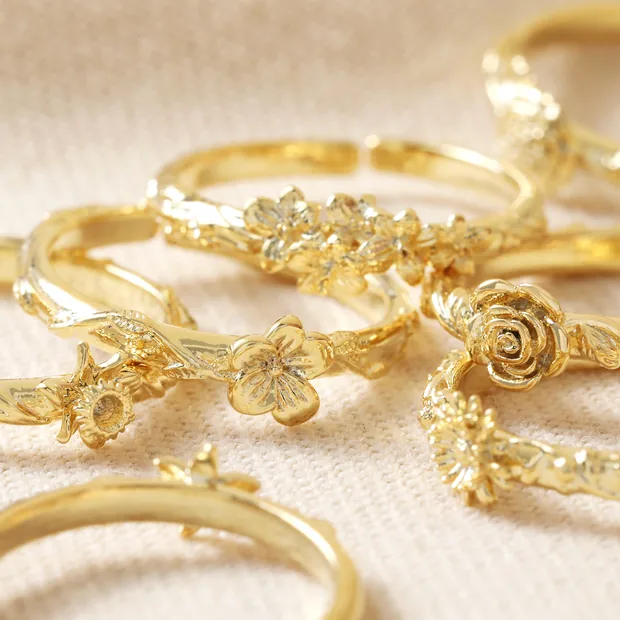 Birth Flower Rings in Gold Multiple Birth Flower Rings in Gold on Beige Surface