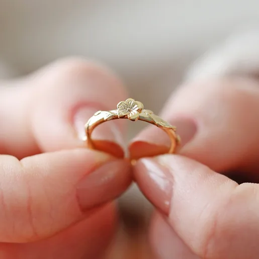 Model Holding February Violet Birth Flower Ring in Gold