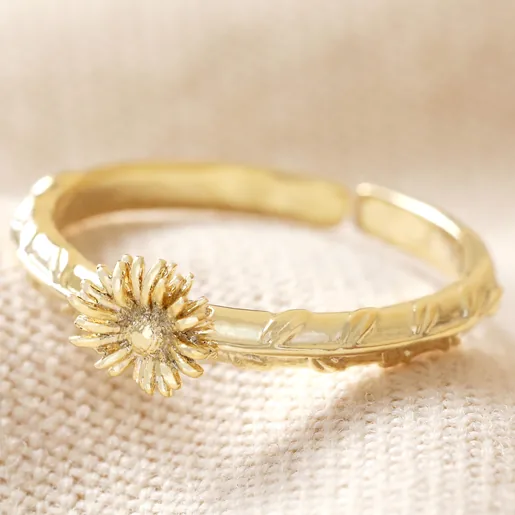April Daisy Birth Flower Ring in Gold on Beige Fabric