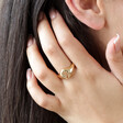 Brunette Model Wearing Crystal Sun and Moon Signet Ring in Gold Pushing Hair Behind her Ear