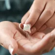 Model Holding Debossed Forget Me Not Signet Ring in Silver Over Palm
