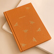 Orange Personalised Bee Fabric Notebook on plain pink surface