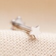 Tish Lyon Solid White Gold Star Helix Earring with Backing on Beige Fabric