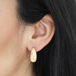 Close Up of Estella Bartlett Chunky Flower Dome Hoops in Gold on Model