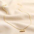 Estella Bartlett Flower T-Bar Necklace in Gold Full Length on Beige Coloured Fabric