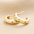 Estella Bartlett Rainbow Crystal Hoop Earrings in Gold on Beige Coloured Background