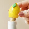 Model Pulling Lemon Cork Bottle Stopper Out of White Bottle