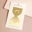 Designworks Ink Celestial Hourglass Metal Bookmark on Cream Packaging