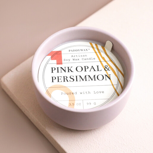 Paddywax Pink Opal and Persimmon Scented Candle with dust cover on top on neutral board with beige background