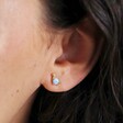 Close Up of Model Wearing Blue Opal Dinosaur Stud Earrings in Gold