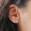 Close Up of Blue Opal Dinosaur Stud Earrings in Silver on Model