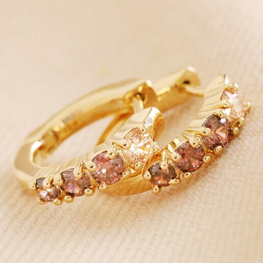 Brown Crystal Huggie Hoop Earrings in Gold on Neutral Fabric