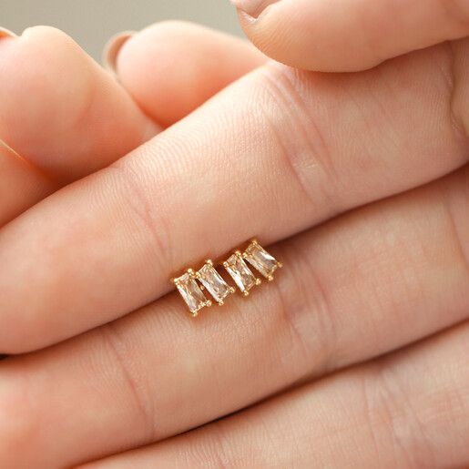 Model Holding Champagne Stone Stud Earrings in Gold