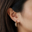 Close Up of Cocoa Organic Resin Hoop Earrings in Gold on Model