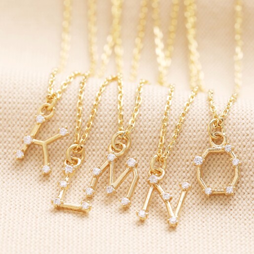 K-O Crystal Constellation Initial Necklaces in Gold K-O Crystal Constellation Initial Necklaces in Gold on Neutral Fabric
