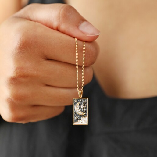 Close Up of Model Holding Crystal Enamel Moon Tarot Card Necklace in Gold in Front of Her