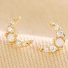 Crystal and Opal Crescent Moon Stud Earrings in Gold on Neutral Fabric