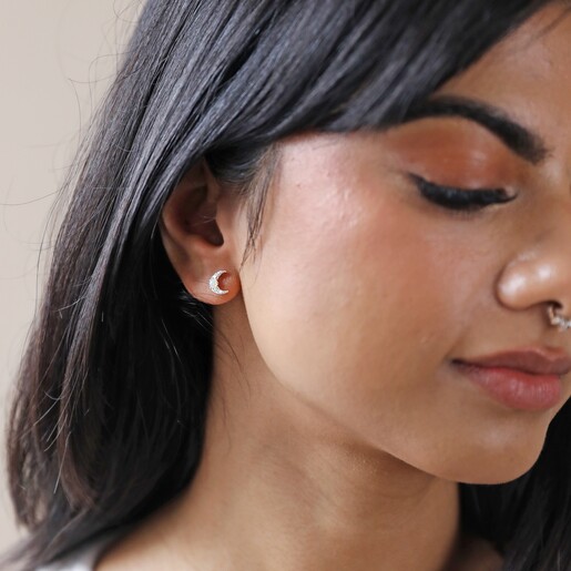 Model Looking Down Wearing Crystal and Opal Crescent Moon Stud Earrings in Silver
