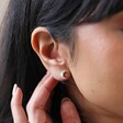 Crystal and Opal Crescent Moon Stud Earrings in Silver on Model with Hand Behind Ear
