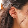Close Up of Crystal Star Ear Cuff in Gold on Model Worn With Other Earrings