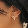 Close Up of Crystal Triple Star Huggie Hoop Earrings in Gold on Model