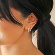 Model Wearing Crystal Triple Star Huggie Hoop Earrings in Gold With Other Gold Earrings