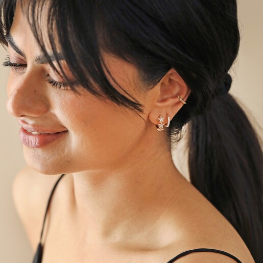 Model Wears Crystal Triple Star Huggie Hoop Earrings in Gold With Other Gold Earrings