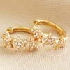 Crystal Triple Star Huggie Hoop Earrings in Gold on Neutral Fabric