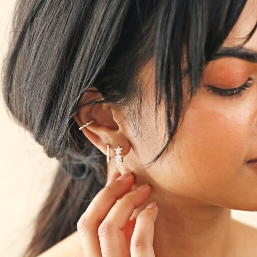 Model Wearing Crystal Triple Star Huggie Hoop Earrings in Silver With Other Silver Hoops