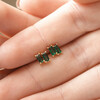 Model Holding Emerald Green Stone Stud Earrings in Gold in Between Fingers