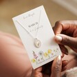 Model Holding March Daffodil Enamel Birth Flower Necklace in Silver on Card