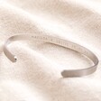Men's Hand-Stamped Stainless Steel Torque Bangle on neutral coloured fabric showing hand stamped message