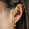 Close Up of Model Wearing Lightning Charm Mismatched Star and Lightning Huggie Hoop Earrings in Gold