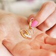 Mixed Metal Oval Link Huggie Hoop Earrings in Gold in palm of model's hand 